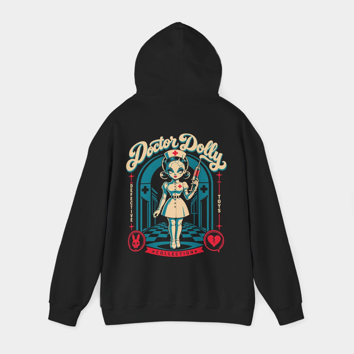 Doctor Dolly black hoodie, hood-raised back view showing a cracked porcelain nurse doll holding a red syringe in a teal hospital corridor, beneath cream Doctor Dolly lettering, with red rabbit and broken-heart emblems.