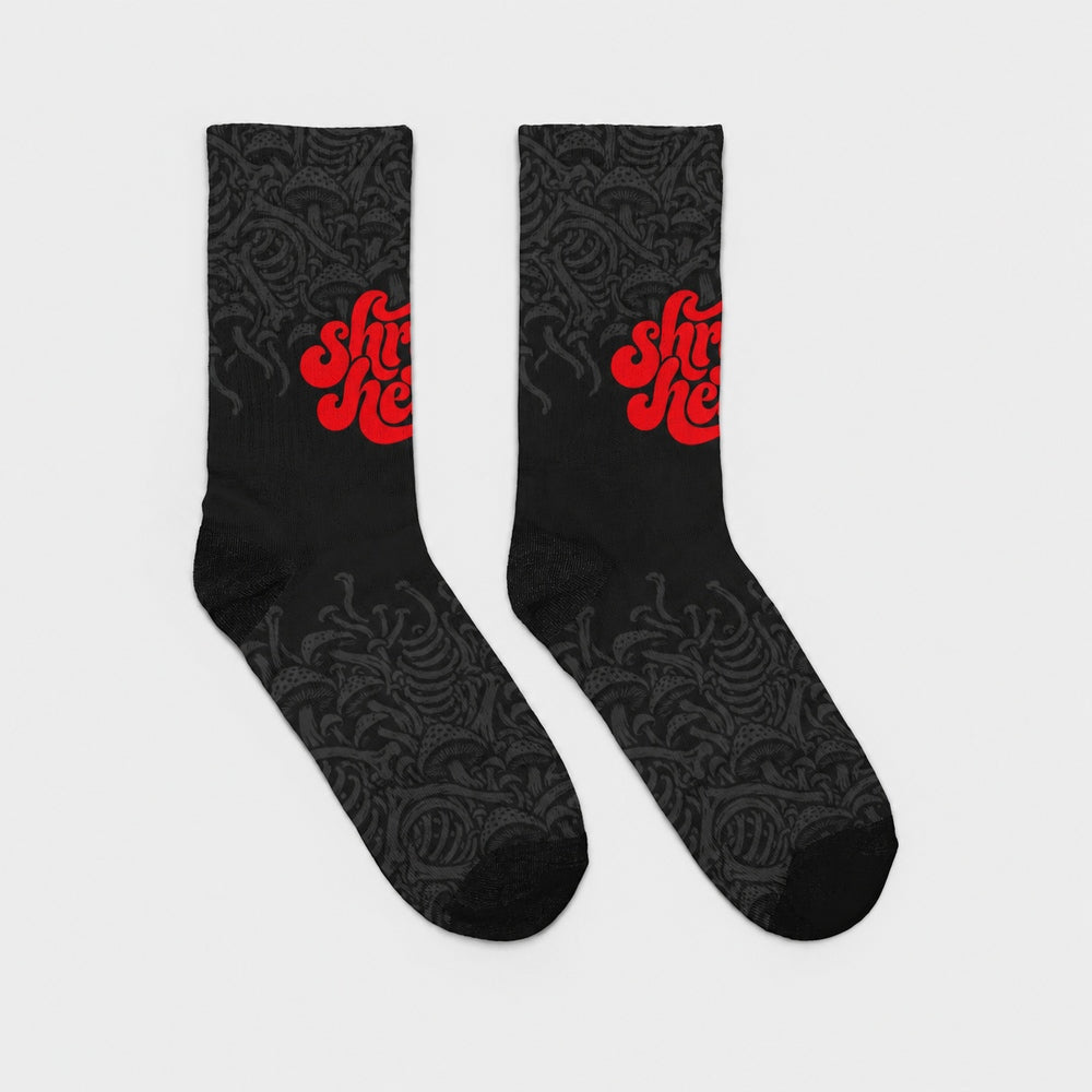 Product-only opposite side view of the pair: black crew socks with fading charcoal mushroom artwork and red Shroomheads script.