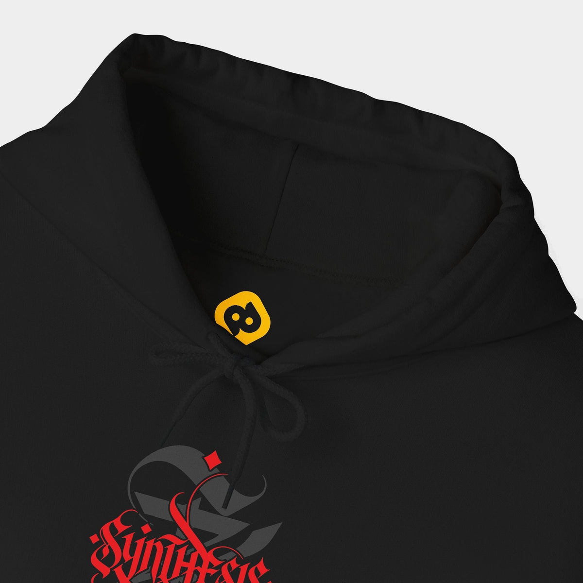 Synthesis black hoodie neckline and chest close-up showing red Synthesis blackletter lettering over a charcoal ornamental S.