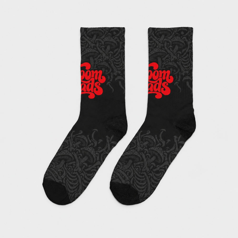 Product-only side view of the pair: black crew socks with fading charcoal mushroom artwork and red Shroomheads script.