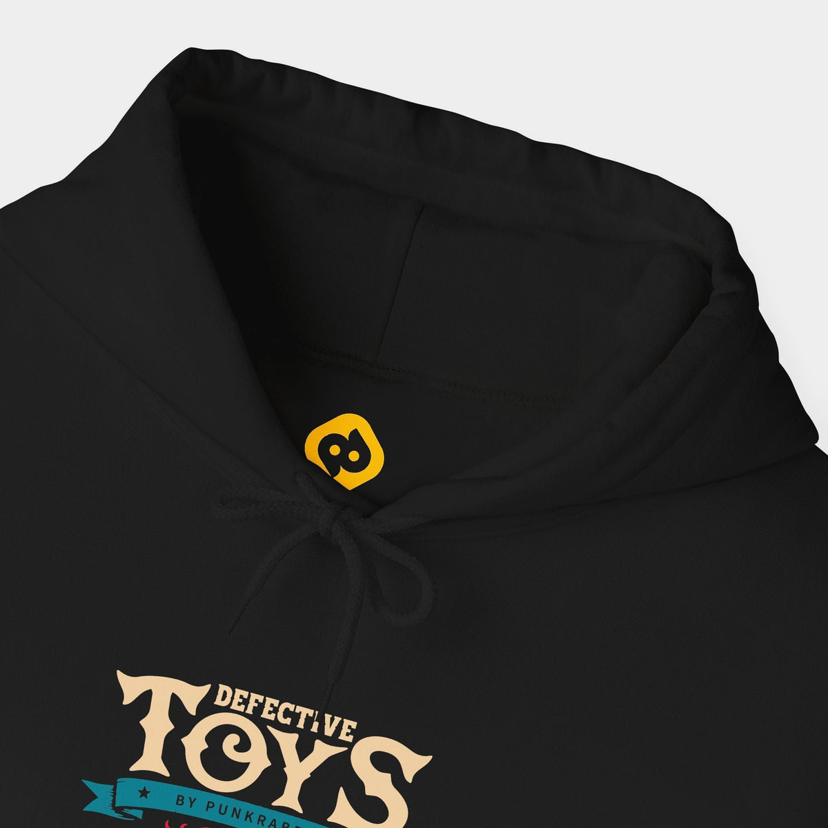 Sinister Sussie black hoodie neckline and chest close-up showing cream Defective Toys lettering above a teal Punkrabbits banner and a small red flourish and yellow neck branding.
