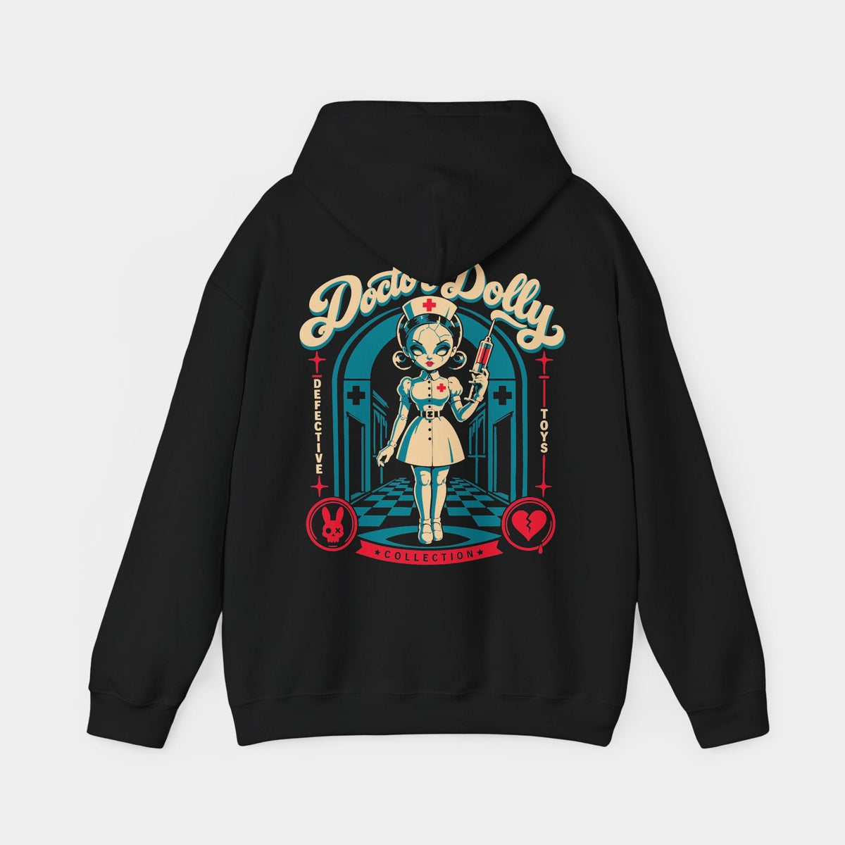 Doctor Dolly black hoodie, back view showing a cracked porcelain nurse doll holding a red syringe in a teal hospital corridor, beneath cream Doctor Dolly lettering, with red rabbit and broken-heart emblems.