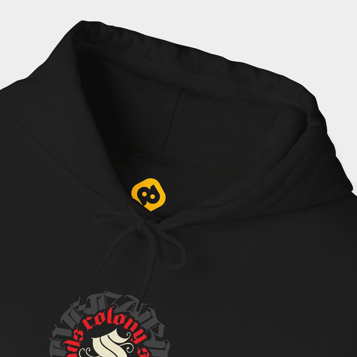 Colony black hoodie neckline and chest close-up showing a circular Colony Shroomheads crest in ivory and red over charcoal lettering.