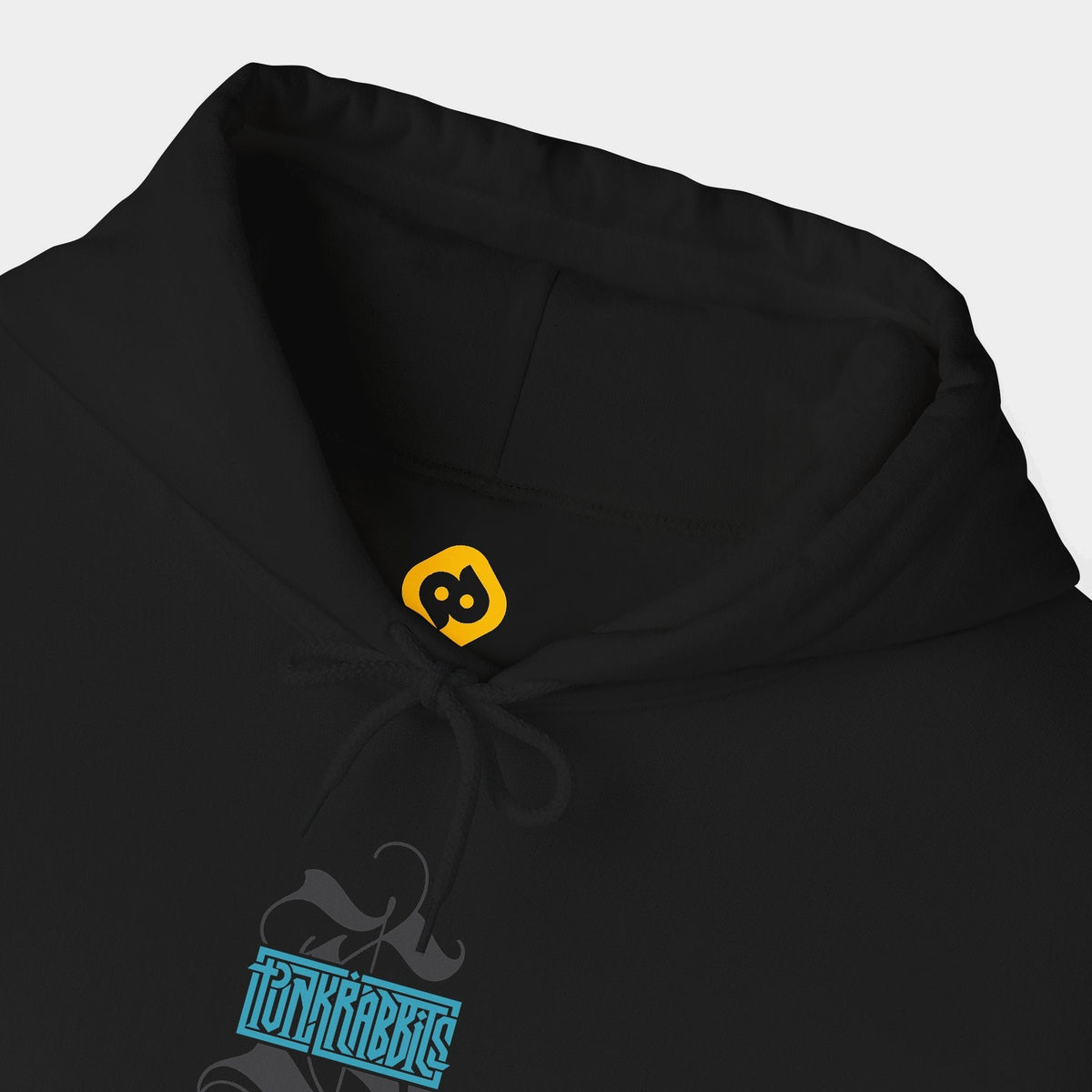 Spore Keeper black hoodie neckline and chest close-up showing a compact blue Punkrabbits wordmark over a charcoal calligraphic motif.