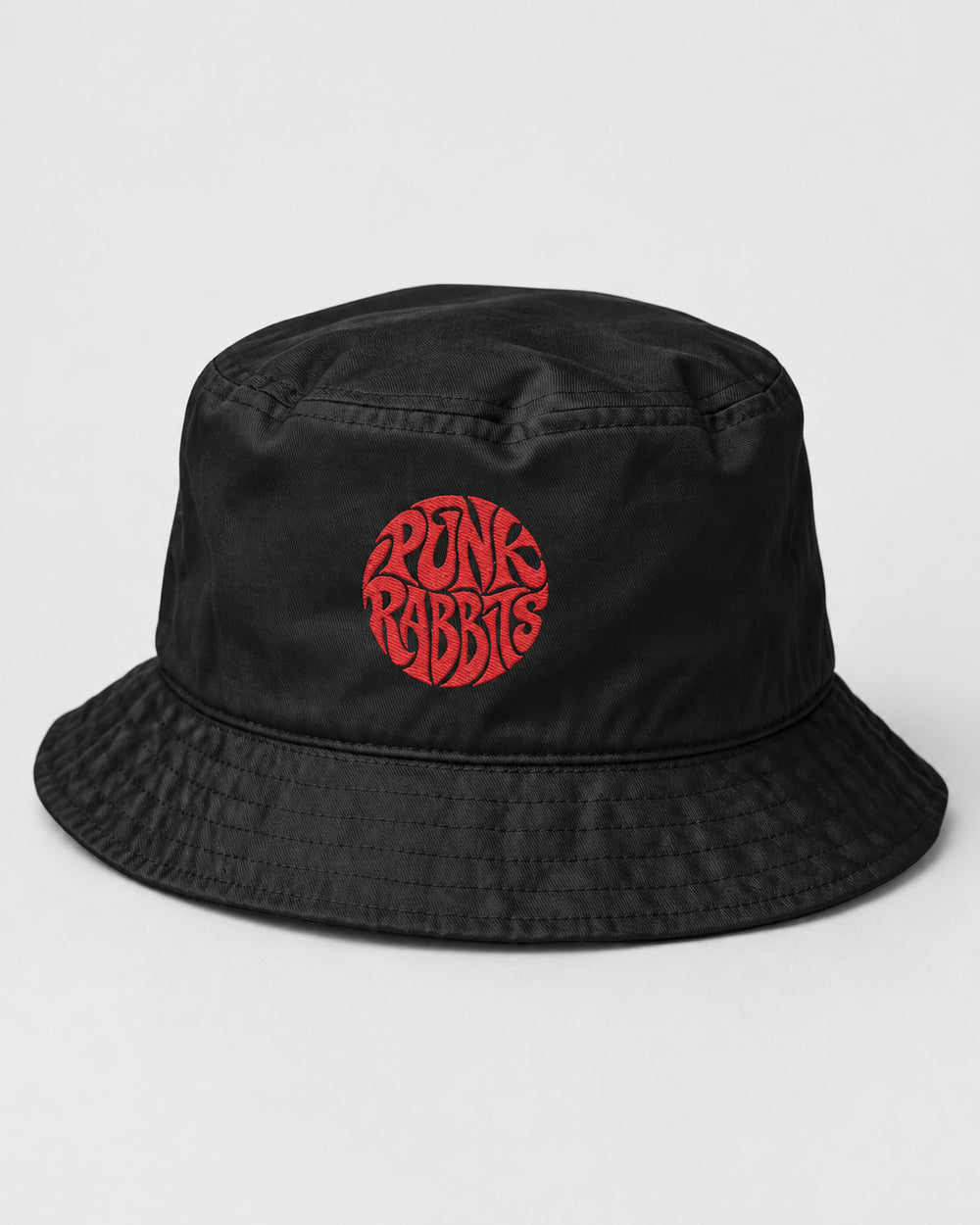 Black cotton twill bucket hat with red circular Punk Rabbits embroidery and naturally soft crown, front view.
