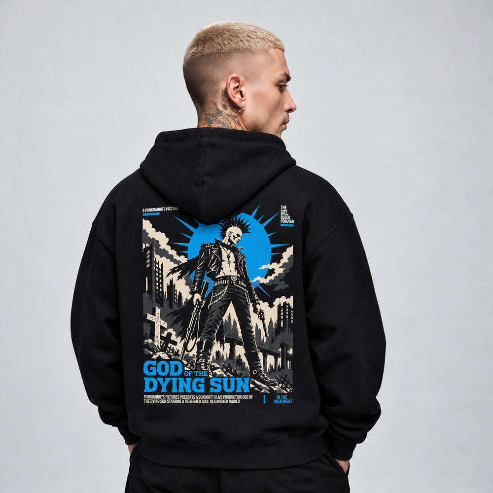 James wearing the God of the Dying Sun black Gildan 18500 hoodie, back view with punk gunslinger among ruined buildings beneath a blue sunburst
