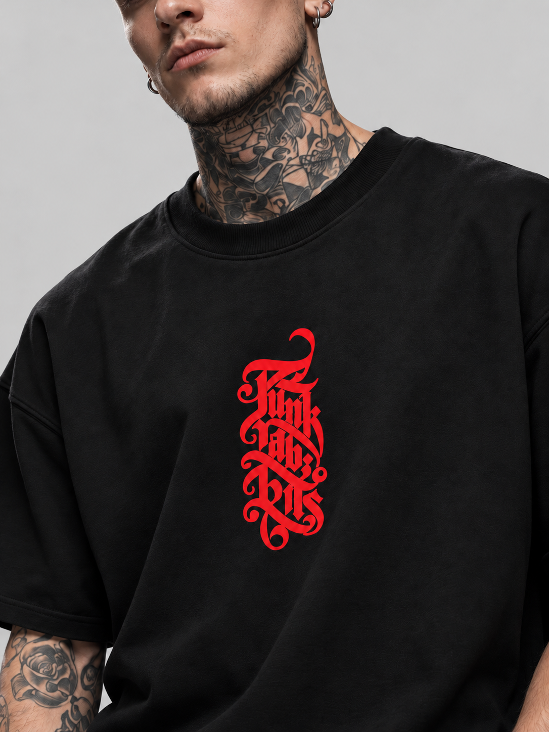 Close-up of black Insurgent Premium Boxy Tee crew neckline, cotton fabric and red chest lettering on James.