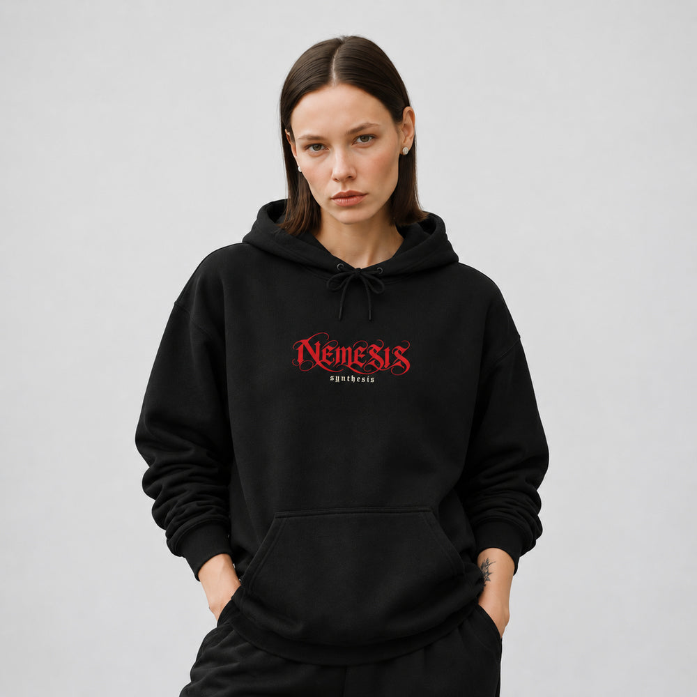 Mara wearing the black Nemesis hoodie, front view showing red Nemesis calligraphic lettering with small ivory Synthesis text.