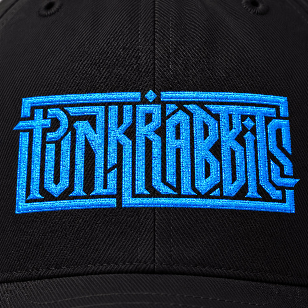 Close-up of blue Punkrabbits embroidery and stitching on black cotton twill.