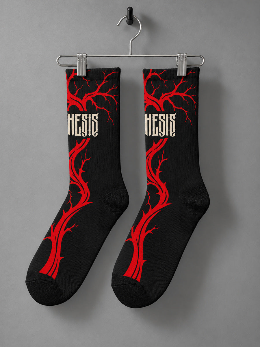 Bleeding Tree Synthesis crew socks, main side with dense red branches and wrapped ivory lettering, hanging as a pair on a metal clip hanger against gray.