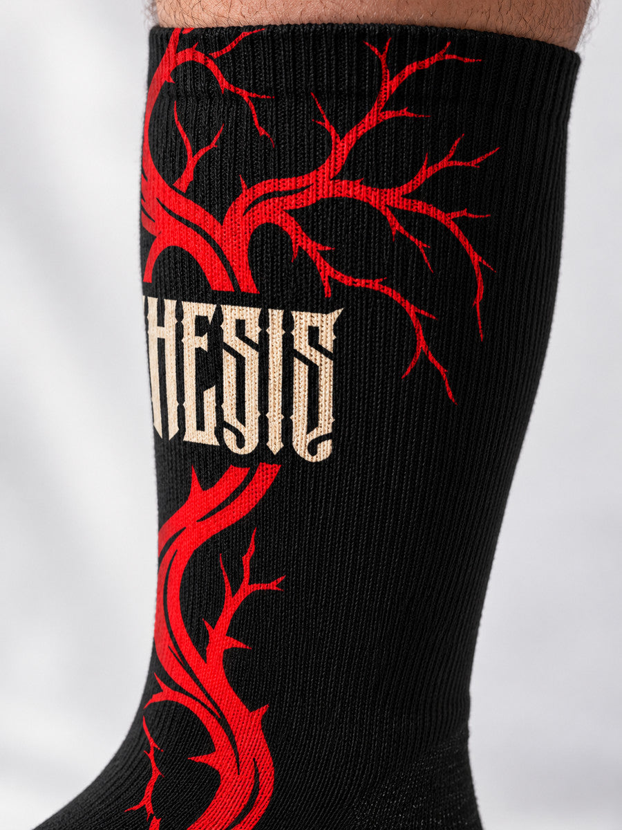 Close-up of the printed red branchwork and ivory angular Synthesis lettering on black Bleeding Tree crew sock fabric.