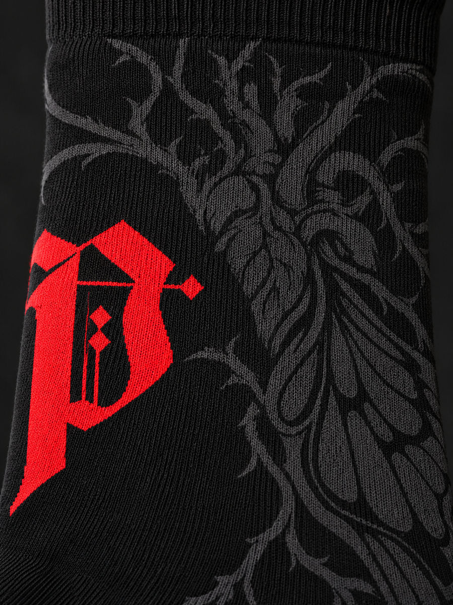 Synthesis Butterfly Roots socks — printed knit macro, outer patterned view, black with red Gothic P and dark gray butterfly roots.