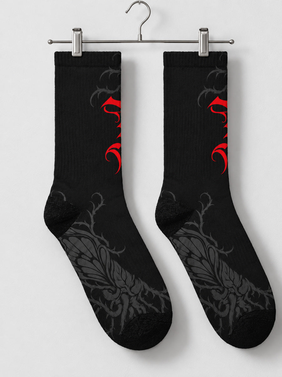Synthesis Butterfly Roots socks — pair on metal clip hanger, actual printed opposite view, black with red Gothic P and dark gray butterfly roots.