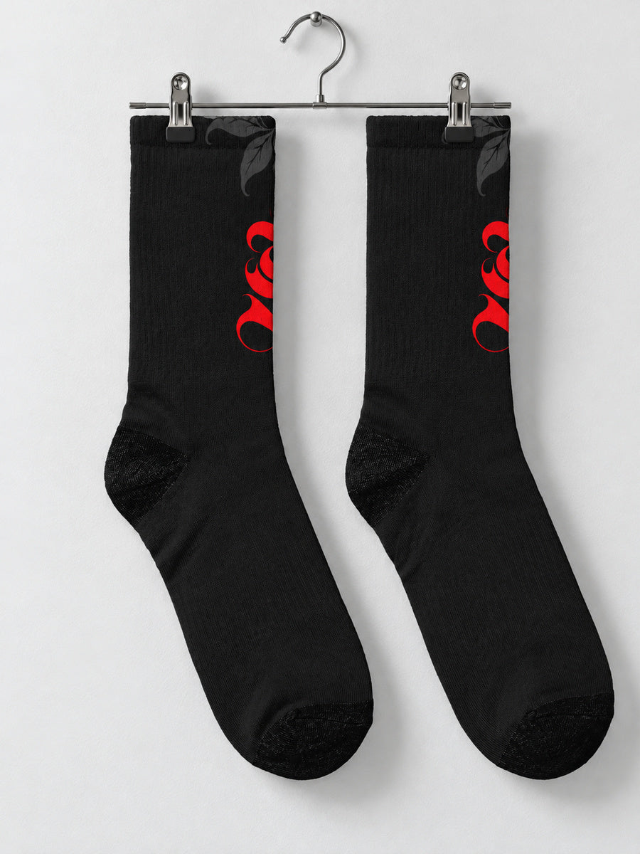 Synthesis Death Grip socks — pair on metal clip hanger, actual printed opposite view, black with red ornate S and dark gray skeletal hands with leaves.