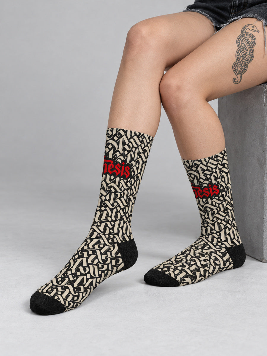 Mara wearing Synthesis script socks in a sock-focused seated gray studio view.