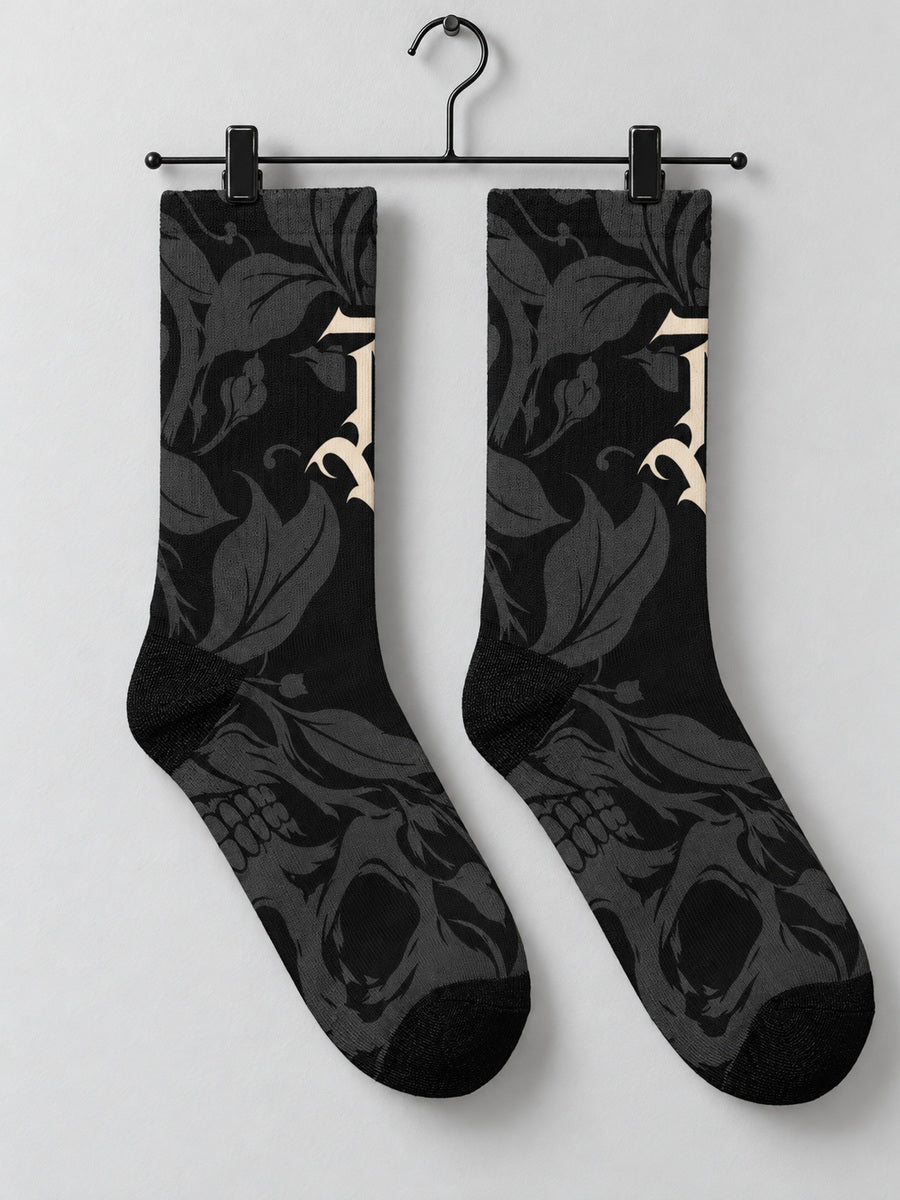 Synthesis skull bloom sock pair hanging from black metal clips, opposite printed view.