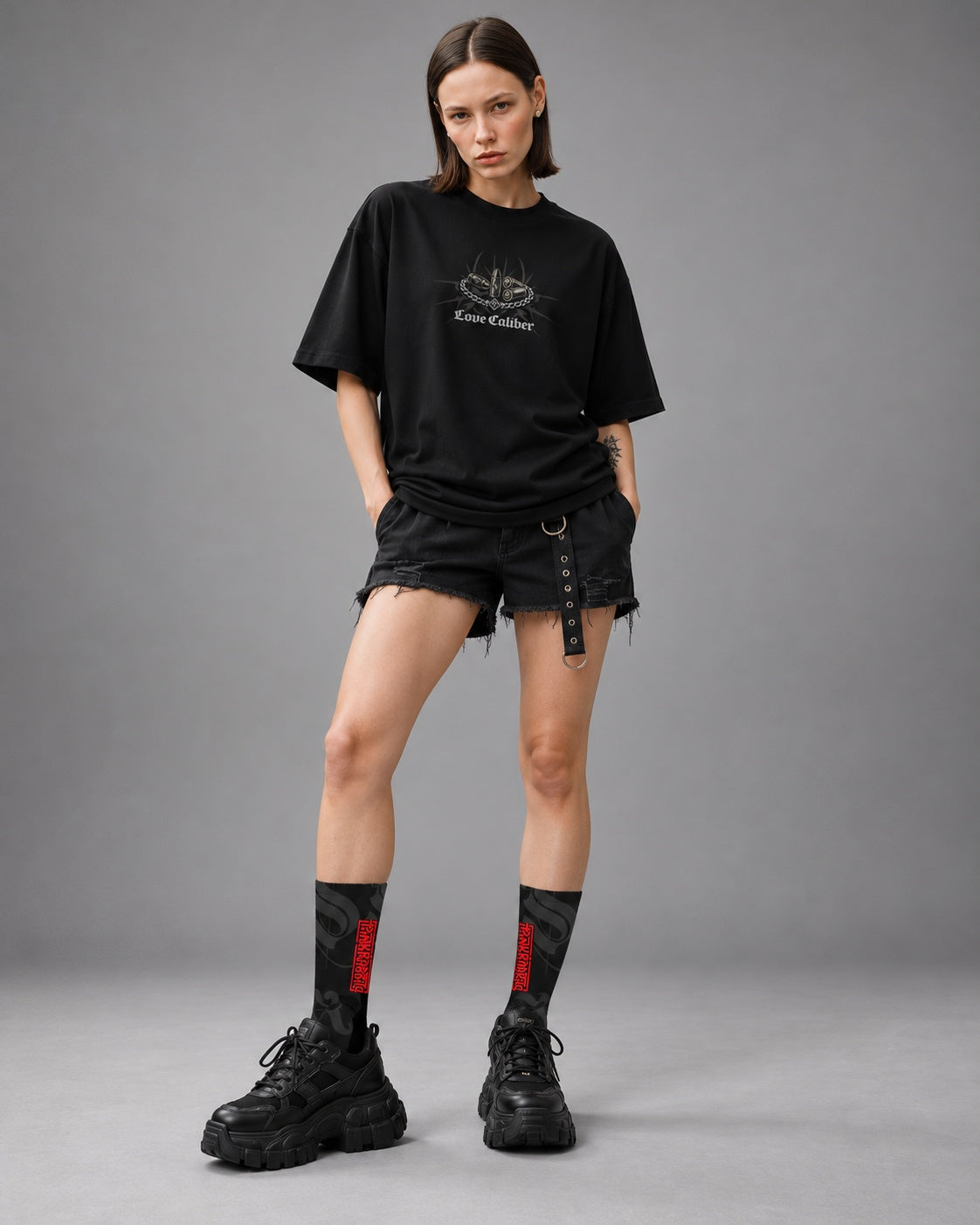 Mara standing in black and charcoal Punkrabbits crew socks with red vertical lettering