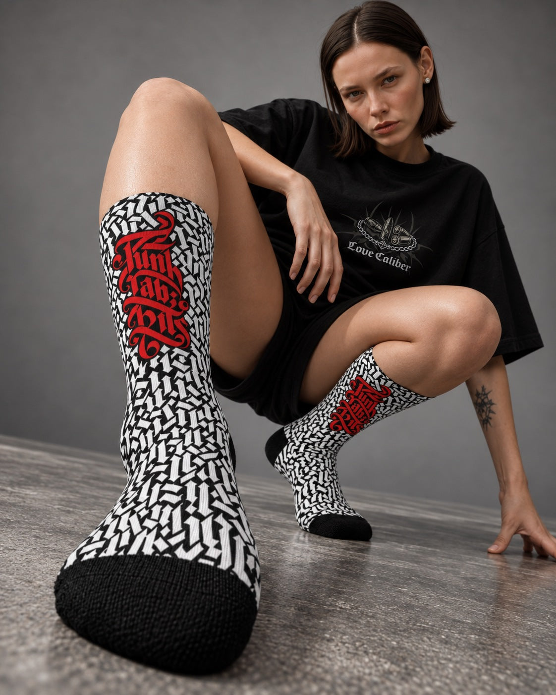 Mara crouching in black and white Punkrabbits Red Script crew socks with red lettering