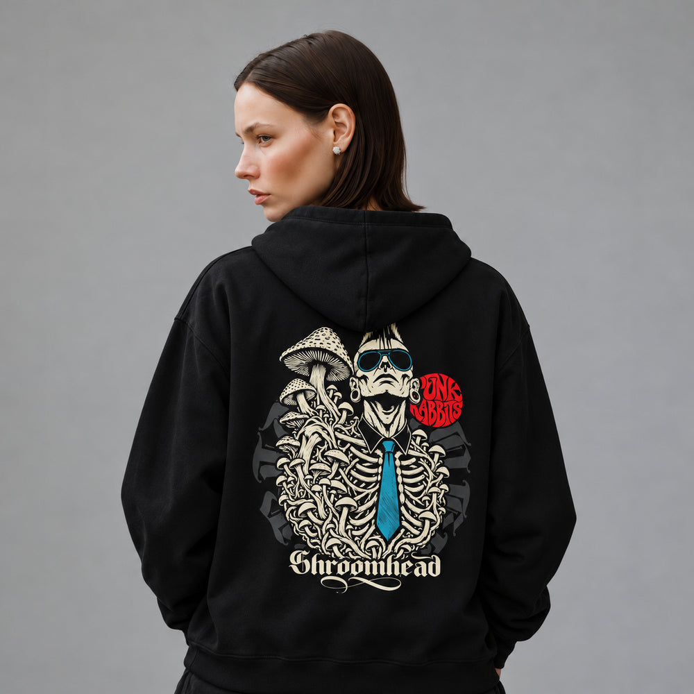 Mara wearing the black Shroomhead hoodie, back view showing a mohawked figure in sunglasses with an exposed ribcage, mushrooms and a blue tie beneath a red Punkrabbits mark.