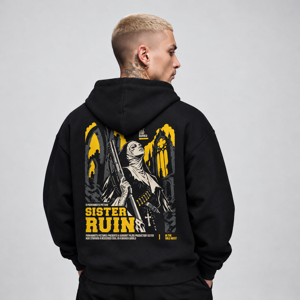 James wearing the Sister Ruin black Gildan 18500 hoodie, back view with armed nun among Gothic ruins in yellow, ivory and charcoal