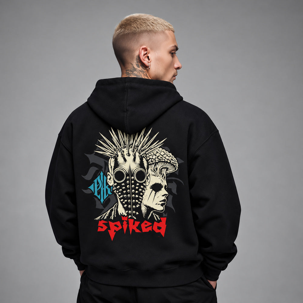 James wearing the black Spiked hoodie, back view showing a punk portrait with a spike mohawk, round goggles and a studded face mask beside a mushroom-crowned profile.