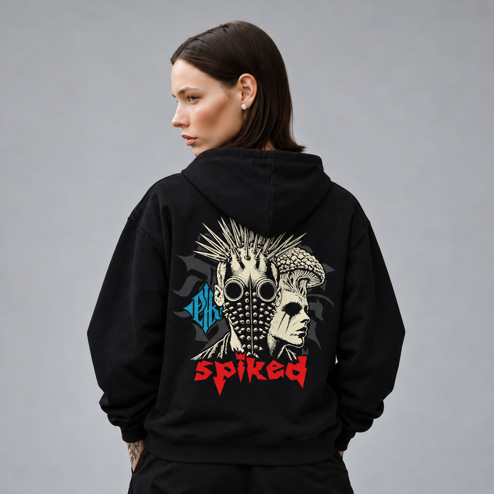 Mara wearing the black Spiked hoodie, back view showing a punk portrait with a spike mohawk, round goggles and a studded face mask beside a mushroom-crowned profile.