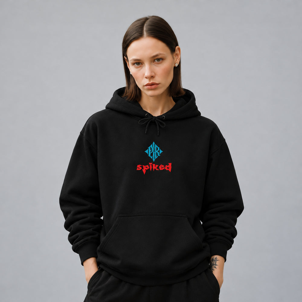 Mara wearing the black Spiked hoodie, front view showing a blue PR diamond above red Spiked lettering.