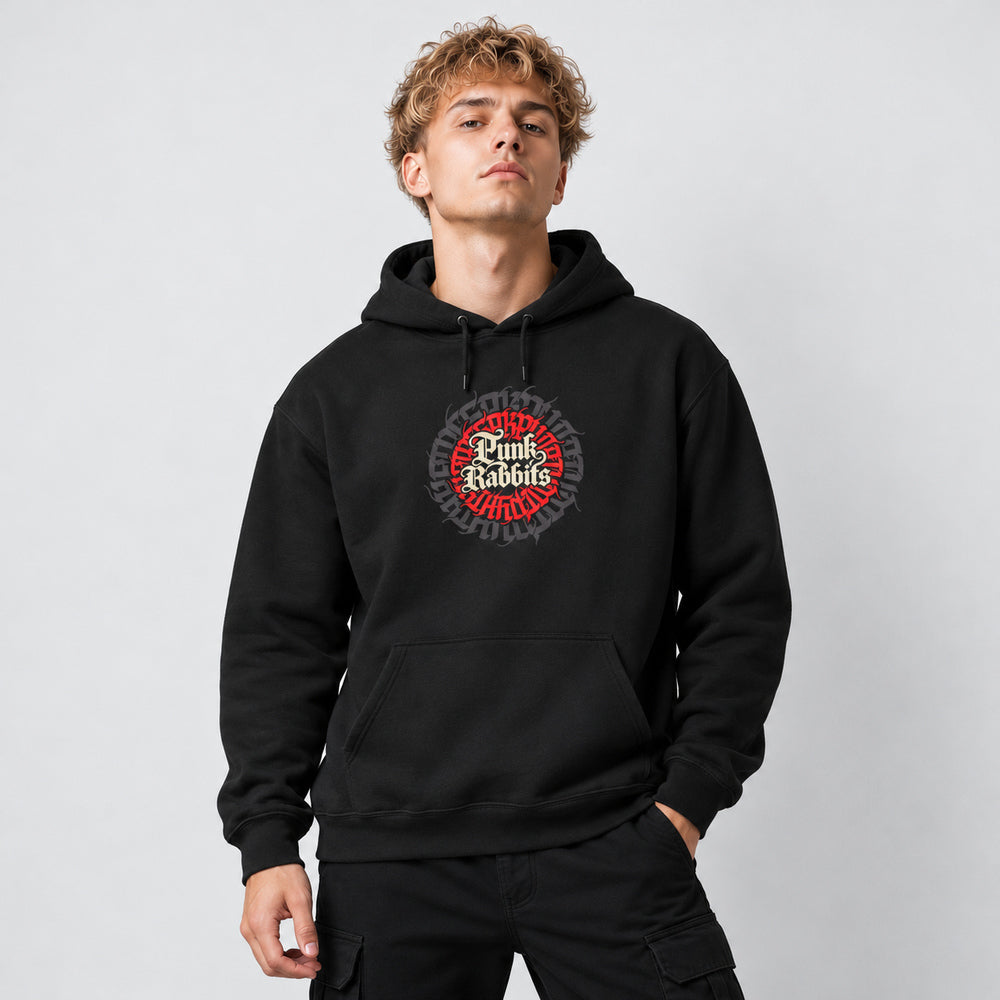 Theo wearing the black Succession hoodie, front view showing cream Punk Rabbits blackletter inside a circular red and charcoal typographic emblem.